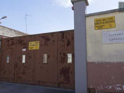 Di fronte si trova invece la caserma Capozzi, anch�essa priva di vita. Siamo per� scossi da un rumore molto forte: ci accorgiamo che l�alto e rosso cancello scorrevole dell�edificio � sganciato da un lato e il vento lo fa muovere